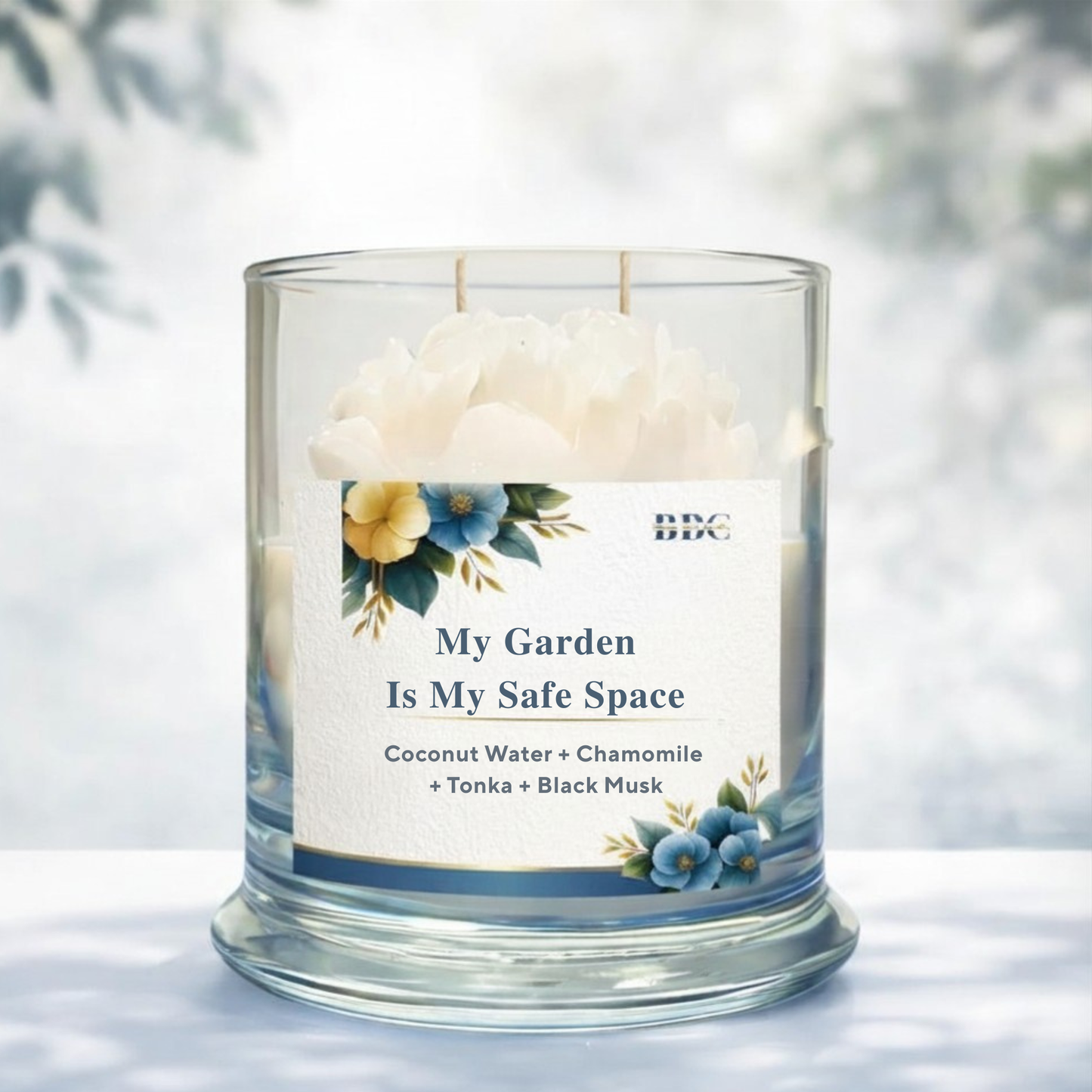 Candle in a glass jar with a label reading 'My Garden Is My Safe Space' on a light background.