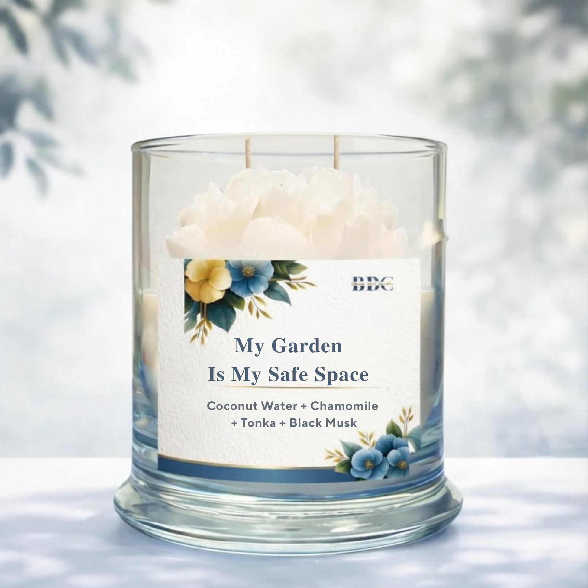 Candle in a glass jar with a label reading 'My Garden Is My Safe Space' on a light background.